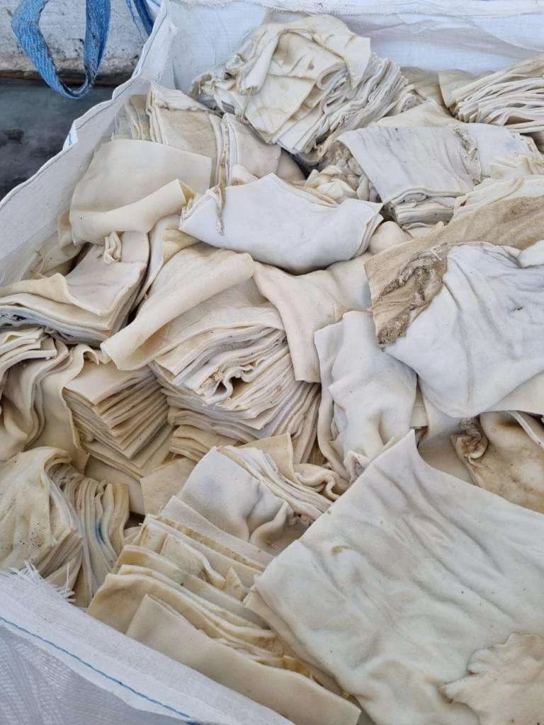 Pieces of treated bovine hide in a bulk bag — gelatin's raw material.