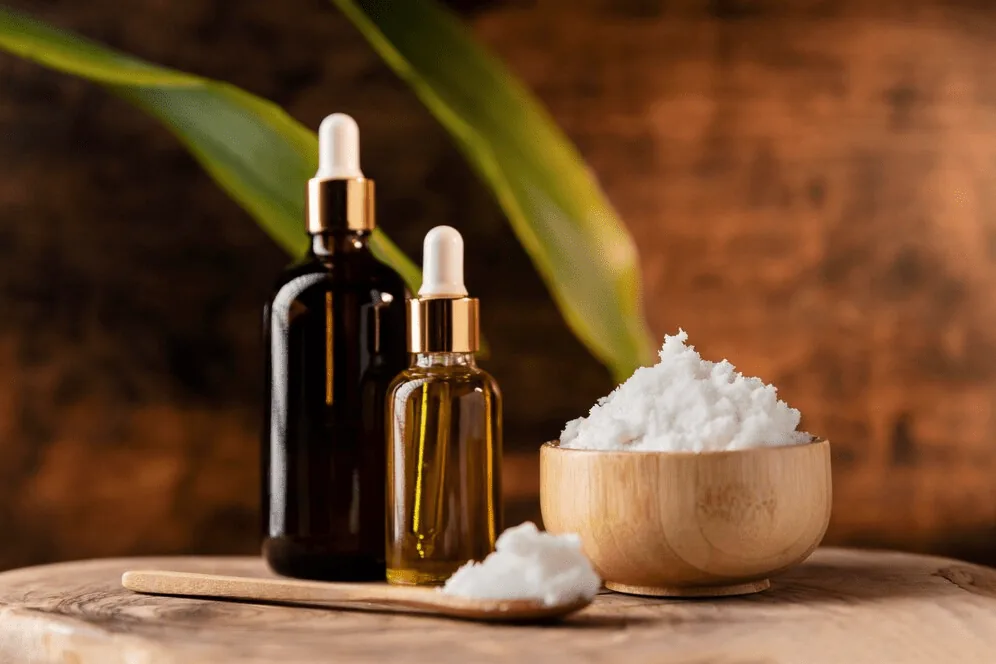 Amber dropper bottles of serum beside a bowl of coconut flakes.