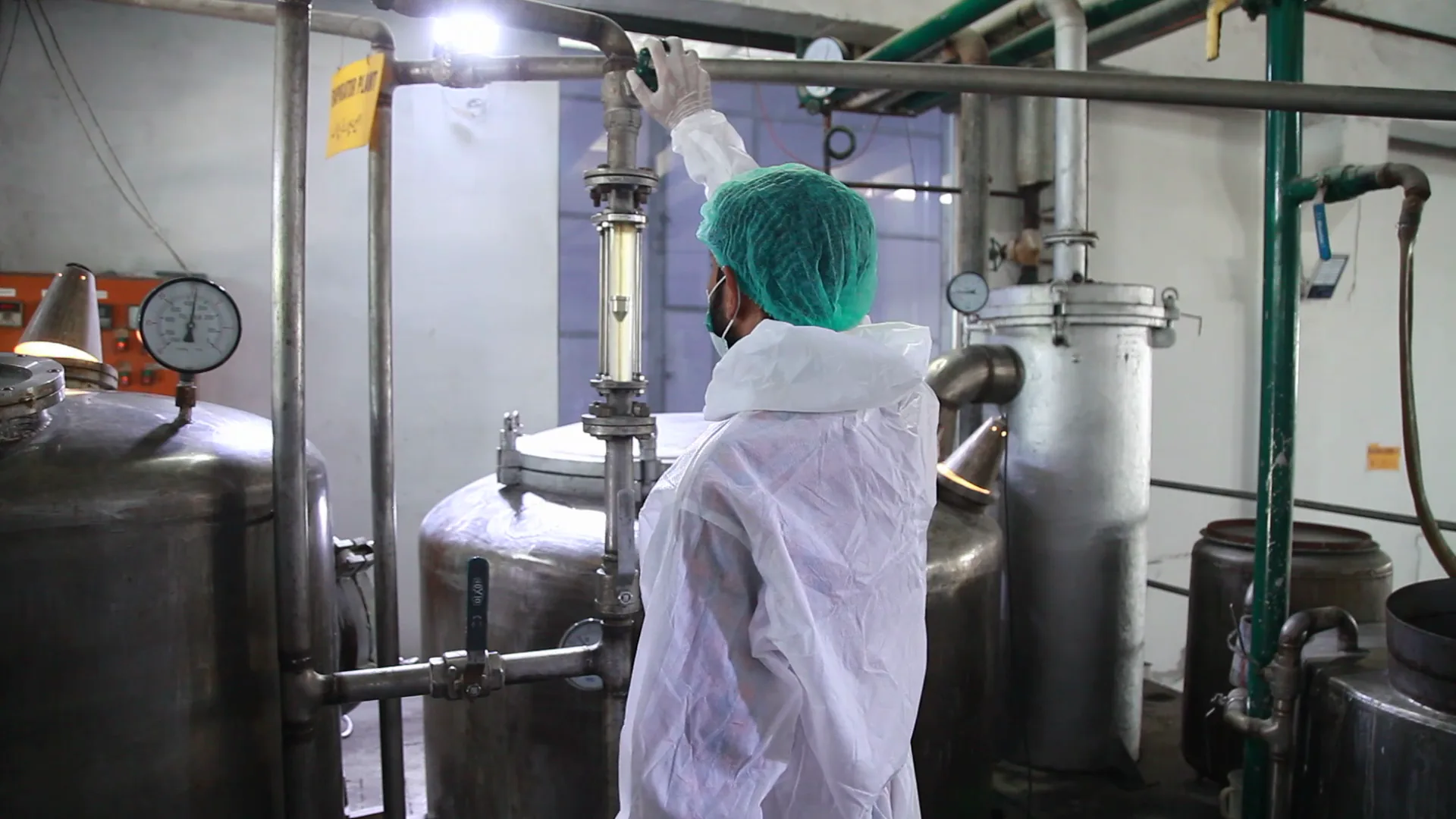 An operator at work among the stainless-steel reactors in the Sadiq Gelatin processing hall.
