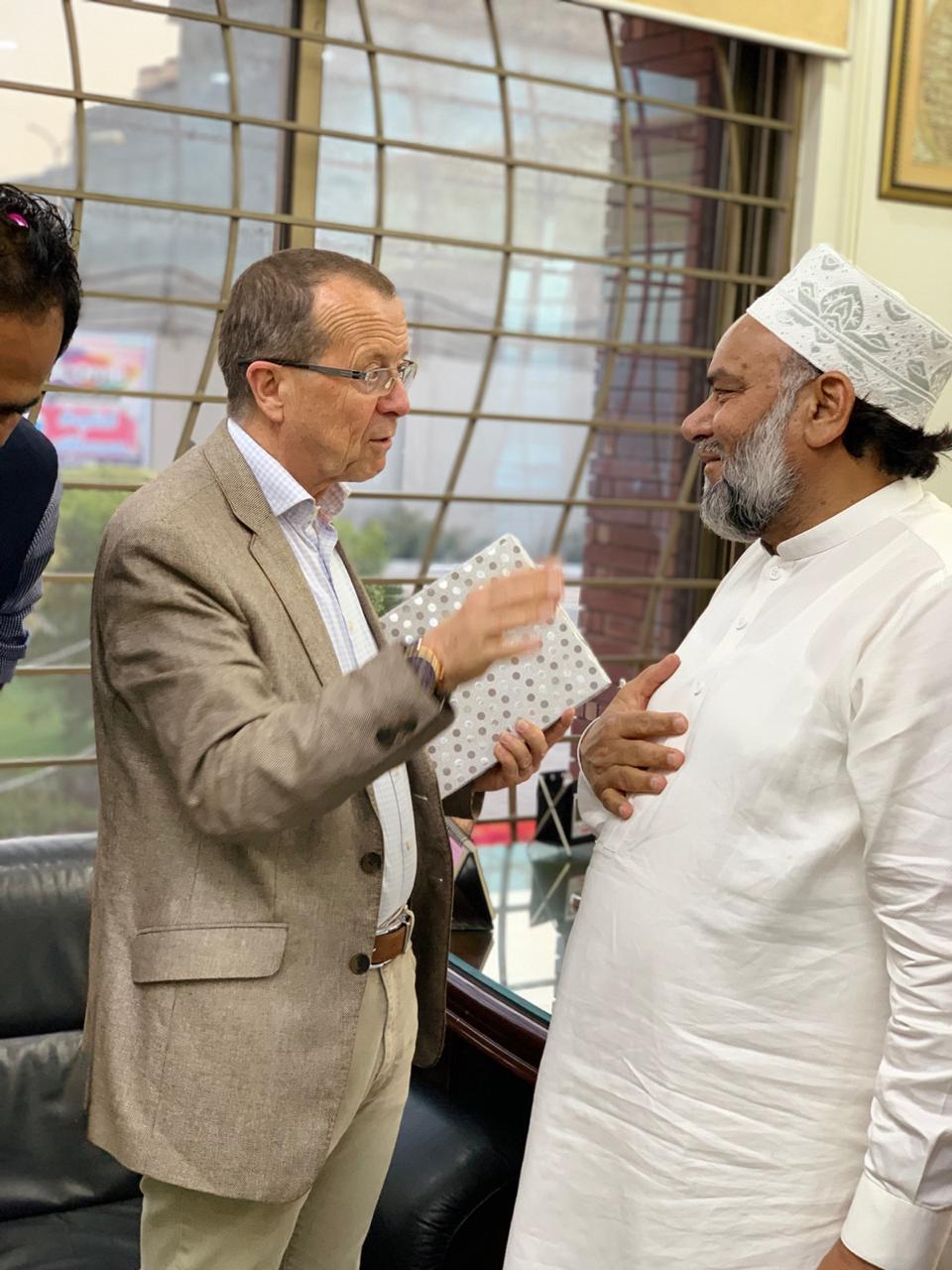 Ambassador Martin Kobler presenting a wrapped gift to Chairman Muhammad Arshad.